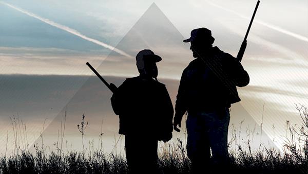 Silhouette of a Father and Son with Shotguns Hunting at Dawn